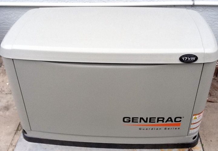 A Generac Guardian Series 17 kW generator installed outside a house. The generator is housed in a beige enclosure with a smooth top cover and the Generac logo prominently displayed on the front. The setup is clean and secure, placed on a concrete pad next to the house wall, ensuring reliable backup power for the residence.