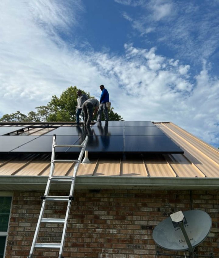 Technicians in Melbourne, FL, are installing solar panels on the roof of a brick house. The panels are arranged in rows, and the workers are positioned on the roof, securing the panels. A ladder is propped against the house, and a satellite dish is visible on the roof. The sky is partly cloudy, providing a bright backdrop for the installation process.